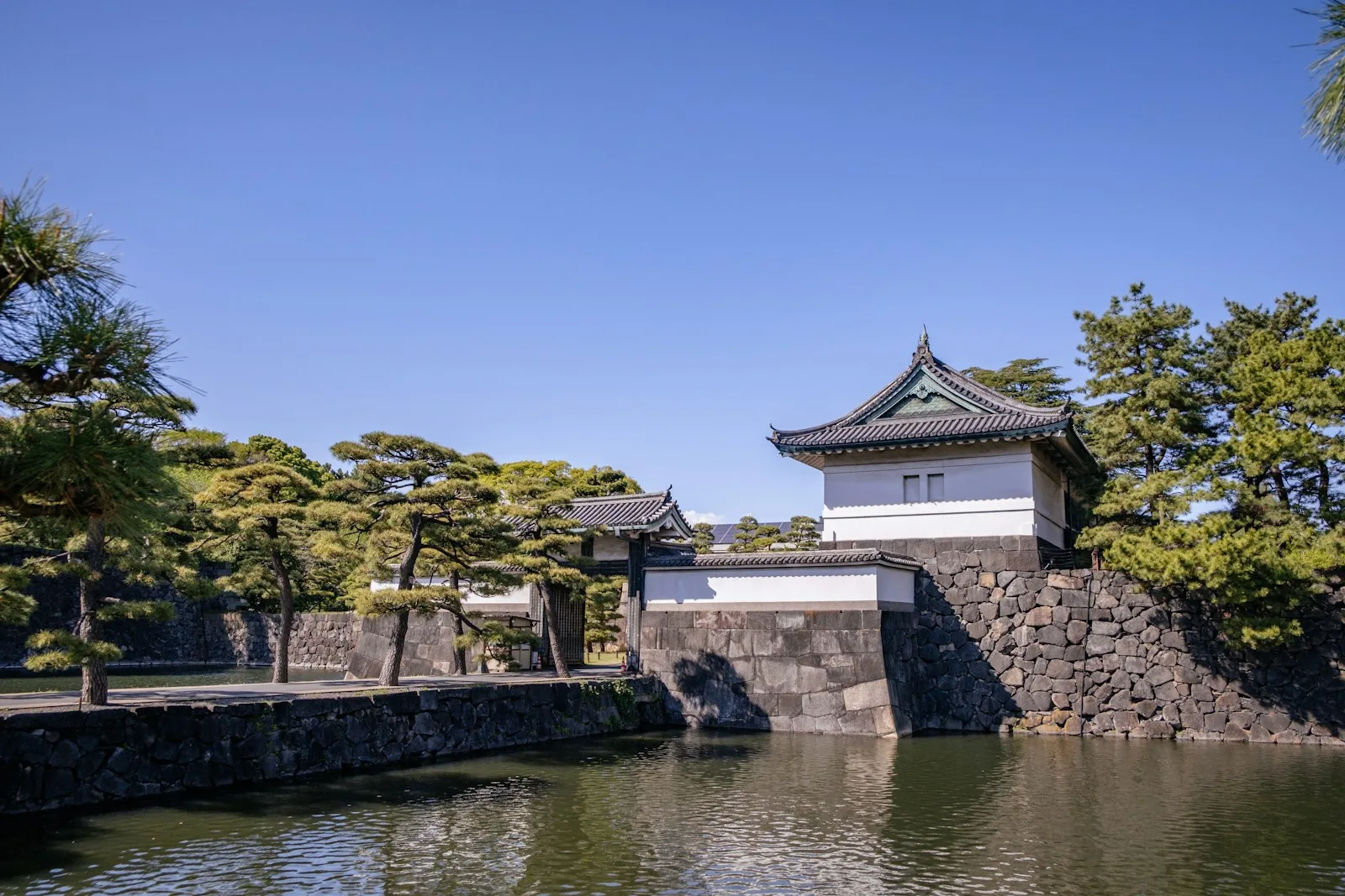 An elegant japanese castle stands beside a waterway