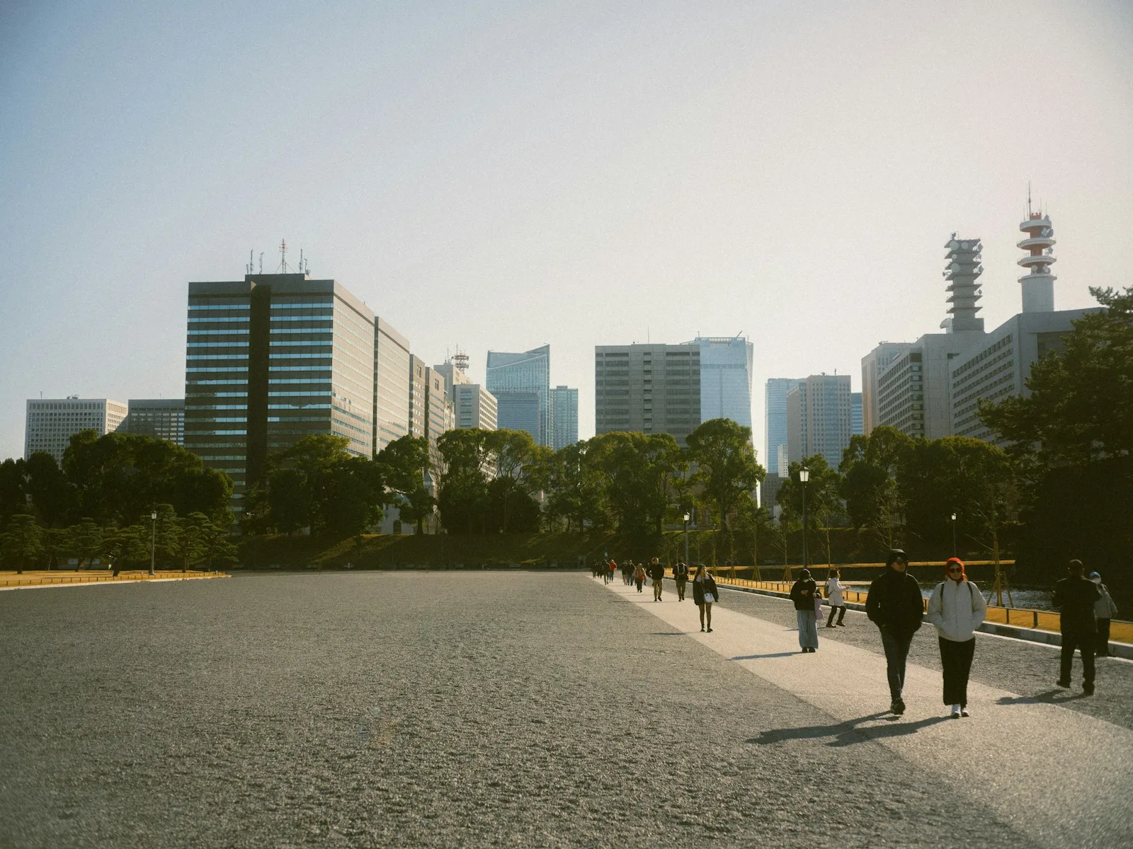 People stroll across a paved plaza in tokyo