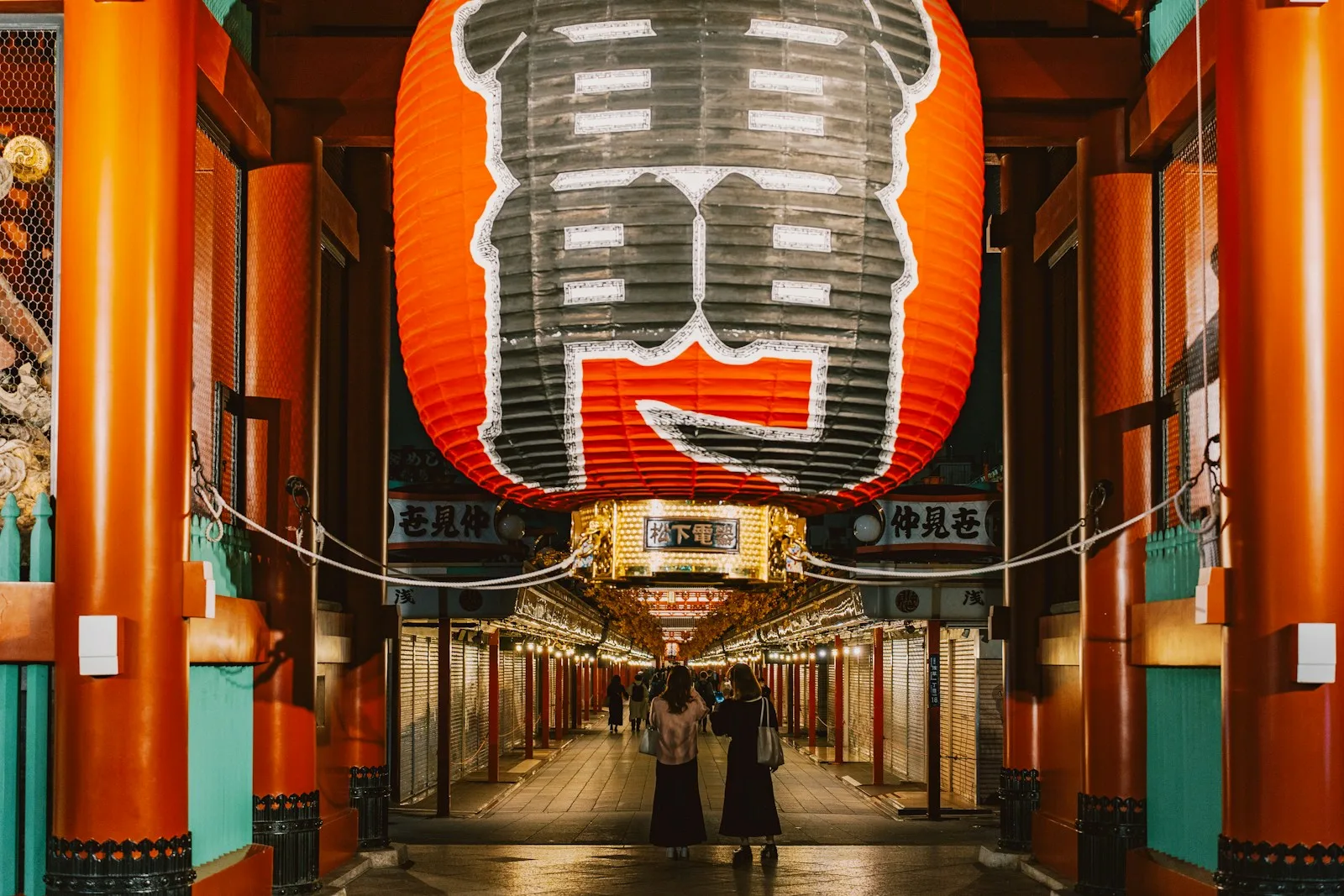 Giant red lantern hangs over a japanese temple walkway