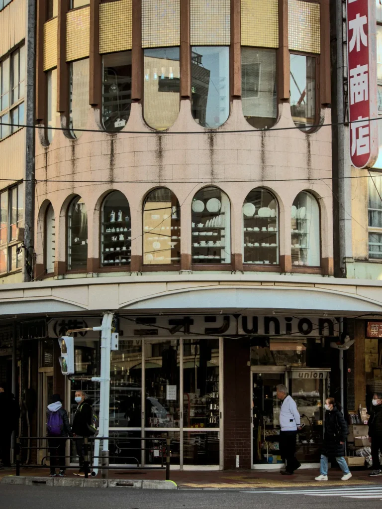 A japanese building's exterior and people walking nearby