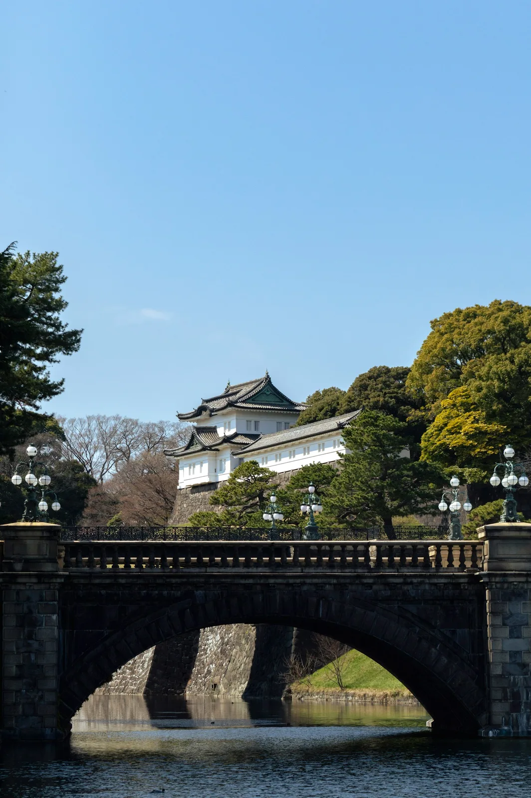 Traditional japanese palace behind a stone bridge and moat
