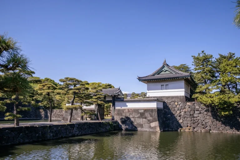 An elegant japanese castle stands beside a waterway