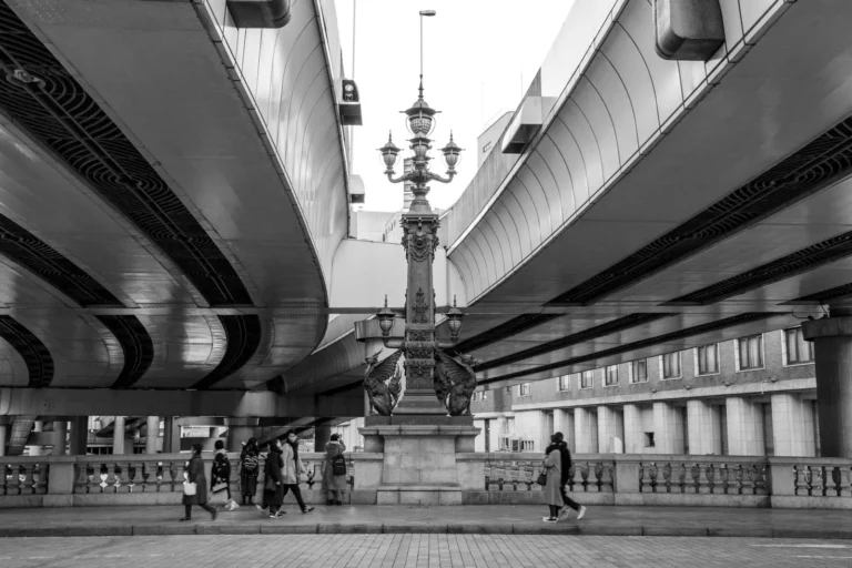 grayscale photography of people walking near walkway during daytime