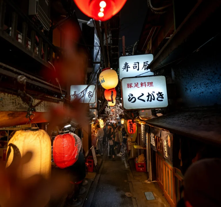 A narrow alley with chinese lanterns hanging above it