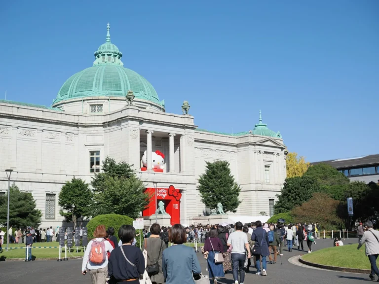 A group of people walking in front of a large building