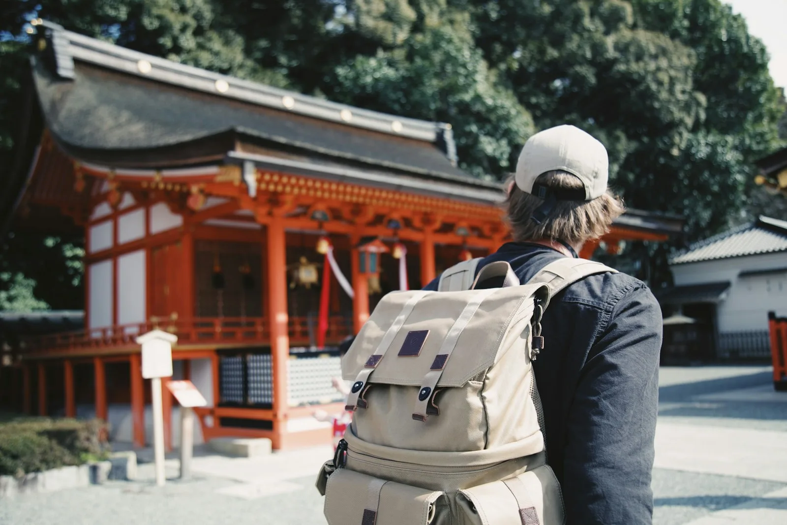 Man wearing black top and backpack near orange structure